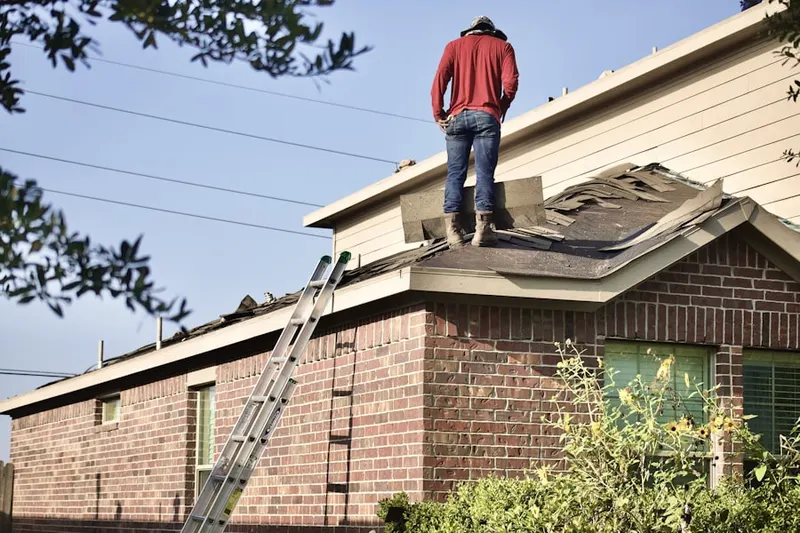 Professional roofer working on a residential roof in Empire